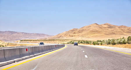 Empty asphalt road across vast hilly landscape of Azerbaijan .endless scenic road across somewhere...