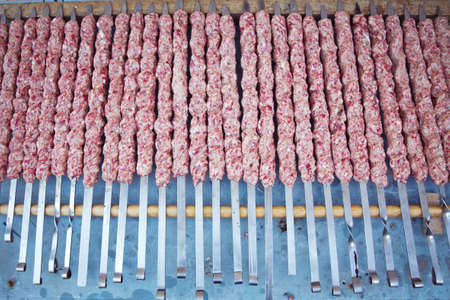 Shish kebab on a metal stick, top view. Lula kebab on skewers , traditional Caucasian dish, close-up...
