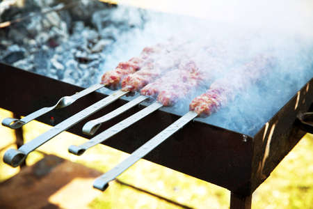 Shish kebab on a metal stick, top view. Lula kebab on skewers , traditional Caucasian dish, close-up...