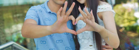 they made a heart out of their hands. A mixed race couple made a heart with their hands .With their hands they have made a heartの写真素材