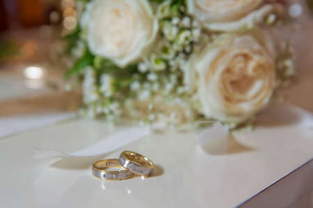 Stylish white wedding flower Rings in front of the wedding bouquet . Wedding rigs in front of a wedding bouquet. Shallow depth of fieldの写真素材