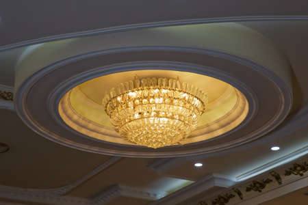 Close-up of a beautiful crystal chandelier . Gilded chandelier with burning candles in the Church....