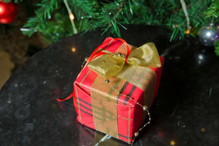 Beautiful Christmas tree with red balls. Gifts under the Christmas tree decorated with golg ribbon...