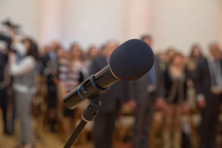 Close up of microphone in concert hall or conference room .Wired microphone set up on the front of conference room close up with blurred background. Wired microphone close up with copy spaceの写真素材