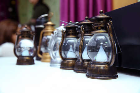 Vintage small old kerosene lamps on a wooden background . Old small oil Lamps in vintage,retro tone...