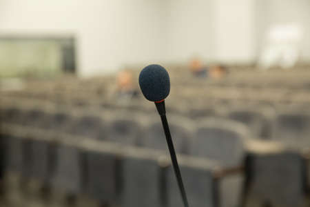Wired microphone set up on the front of conference room close up with blurred background. Wired microphone close up with copy space . Close up of microphone in concert hall or conference room .の写真素材