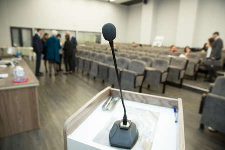 Wired microphone set up on the front of conference room close up with blurred background. Wired microphone close up with copy space . Close up of microphone in concert hall or conference room .の写真素材