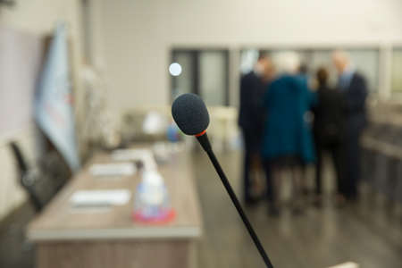 Wired microphone set up on the front of conference room close up with blurred background. Wired...
