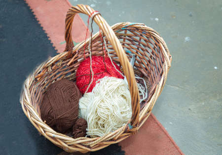 Drawing brown basket with a handle with balls of wool and knitting. Set for sighting and needlework. ball of wool and knitting needles in basketの写真素材