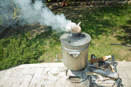 Vintage metal copper tea samovar. Samovar side view. Retro soot grunge tea samovar was used for a long time. Burned with firewood .Ancient Azerbaijan samovar. A device for making tea. the white smokeの写真素材