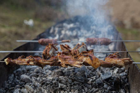 Shish kebab on a metal stick, top view. Lula kebab on skewers , traditional Caucasian dish, close-up . Appetizing lula kebab grilled on metal skewer.の写真素材