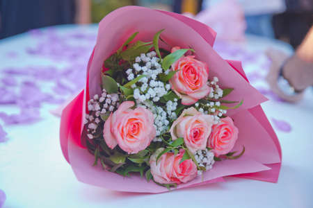 Bouquet of pink flowers in pink paper.top view of beautiful pink bouquet in wrapping paper on white...