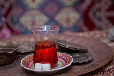 Black turkish tea in pear shape glass, traditional Azerbaijani aromatic tea in armudu cup . Tea in Azerbaijani traditional armudu pear-shaped glass . Azerbaijan black tea .white sugar cubesの写真素材