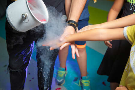 Chemical event at the birthday party: children's hands touch the smoke from liquid nitrogen. The...