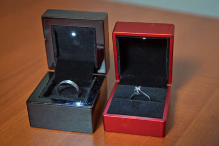 wedding ring in black and red box woiden background . Couple wedding rings in a gift box isolated on...