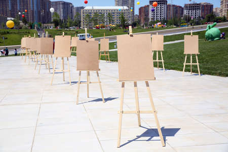 Wooden easel with blank canvas . Pair of Easel with blank canvas . Blank art board and realistic wooden easel outdoors. Drawing board easel blank exhibition at city street .の写真素材