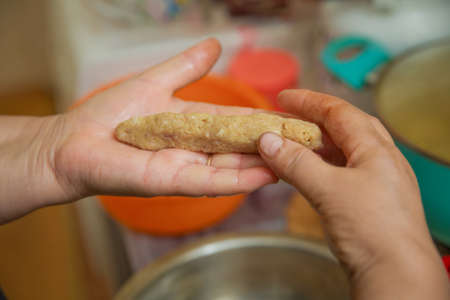 Hands with meatballs cutlets close-up. Right frame - hands sculpt cutlets. Woman hand making...