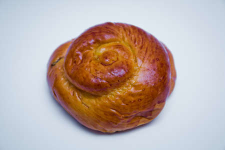 Fresh bake cinnamon roll with a cherry . Freshly baked sweet bun with raisins isolated on white...