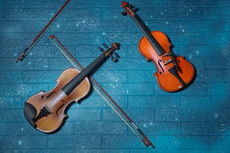 Red and brown Violin and tar blue in the background.Violin in front of blue brick wall .Classical music concert poster with orange color violin on blue background with copy space for your textの写真素材
