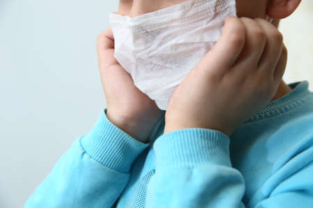 Kids wearing her mask is not comfortable, she has headache. Sick Child wearing surgical mask...