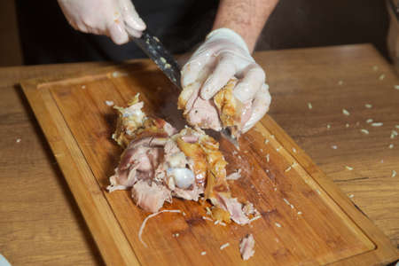 Cut the cooked lamb with a knife. The cooked lamb cut the meat on the board.