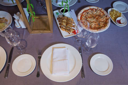 empty glasses and plates on the table in the restaurant . Tables set for meal . fork, knife , table...