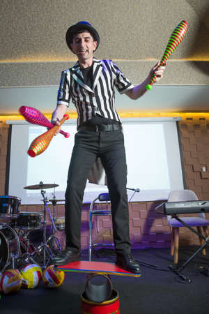 Baku, Azerbaijan - 11.03.2020 . Man standing on top of cylinders and juggling glass bottles, one bottle broke. A series of drawings about the circus. Juggle clubs. clown riding a unicycle on a beamのeditorial素材