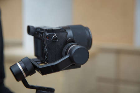 An unidentified man holding gimbal a camera stabilizer . Man holding gimbal stabilizer outdoor....
