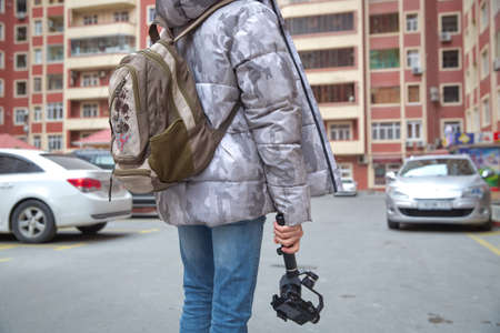 A man holding a camera mounted on a gimbal. Gimbal Operator with black equipament - Stabilizer and camera filmmakingの写真素材