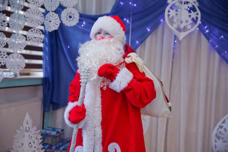 Baku, Azerbaijan . 12.01.2018 . Father Frost speaks with a microphone . Santa Claus is singing Christmas songs against . Man in Santa Claus suit posing with microphone.のeditorial素材