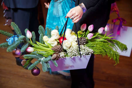 Woman hand holding flowers. Bouquet of flowers for congratulations. close up photo of young woman holding bouquet of flowers. women hand holding flowers bouquet on the dark backgroundの写真素材