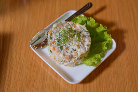 Azerbaijani capital salad.On the plate capital salad.Mayonnaise salad. Food background - salad olivier close-up. Green peas, cucumber, potatoes, sausage, mayonnaiseの写真素材