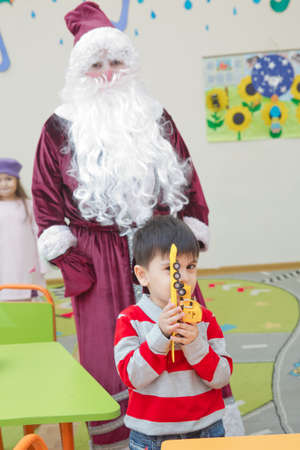 Baku, Azerbaijan . 26.01.2020 . New Year celebration in Azerbaijan kindergarten with Ded Moroz (Grandfather Frost) . The child takes a photo with Santa Claus.のeditorial素材