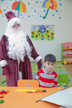 Baku, Azerbaijan . 26.01.2020 . New Year celebration in Azerbaijan kindergarten with Ded Moroz (Grandfather Frost) . The child takes a photo with Santa Claus.のeditorial素材