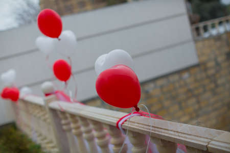 Red and white heart balloons with ribbon for engagement . Heart red and white balloons in the skyの写真素材