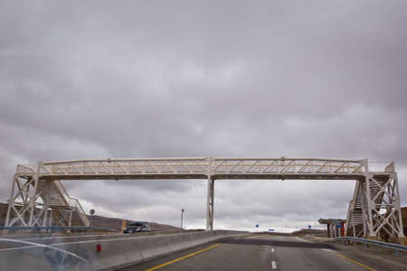 The pedestrian crossing bridge . Bridges crossing people without a roof. Open road with blue clouds...