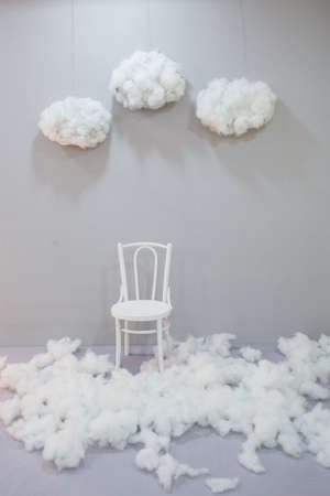 White wall white chair white floor. Cotton snow and cotton clouds in the sky. Cotton ball as a wool and earsticks . Studio backgroundの写真素材