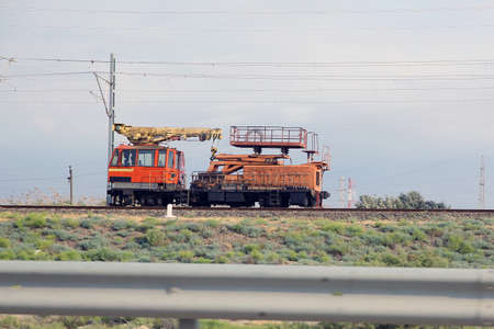 tie crane doing the railroad maintenance at train station. Crane for Railways on track it is used to...