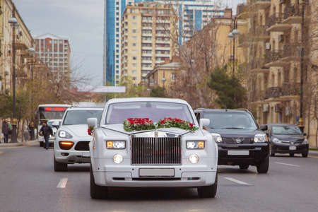 Baku, Azerbaijan 12.04.2017 . White luxury cars parked in luxury district near pretty houses at wedding. Bentley, Porsche, Rolls-Royce, Mercedes-Benz . Wedding cortege in the Baku Street city centre .のeditorial素材