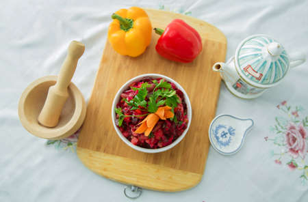 Beets, carrots, cabbage served on a wooden board . Slices of boiled beets in a plate. Healthy food,...