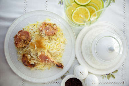 A bowl of white ceramic salt and pepper. Shah pilaf. Khan pilaf in a pita. Black pepper in a white ceramic pot . There is chicken meat on the pilaf .の写真素材