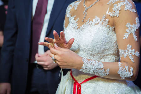 The brides is wearing a ring on the bride's hand . room Dresses the Ring for the Bride, close-up....
