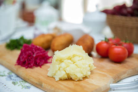 Chicken Kiev cutlets with parsley leaves. Ukrainian tradition food on a wooden board . Red cabbage...