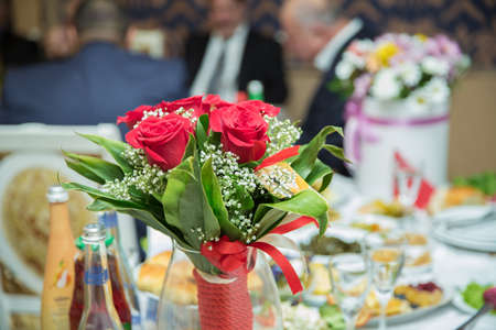 red wedding bouquet in a glass jar . Red rose bouquet . Beautiful green bouquet of red flowers in a glass vaseの写真素材