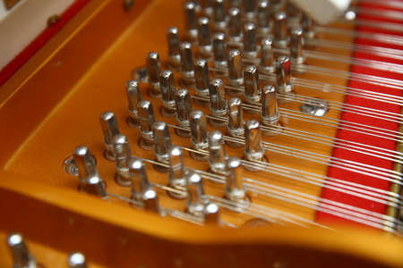 Hammers in abandoned piano striking strings tuned to produce the note when a piano key is pressed....