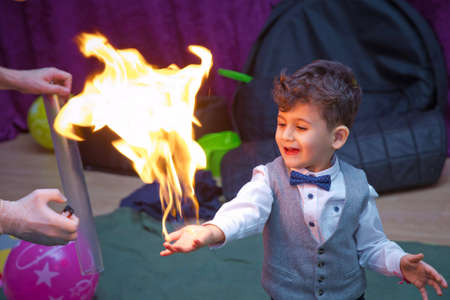 Baku, Azerbaijan . 04.02.2020 . They rubbed foam on the child's hand, then filled the foam with gas and burned it. Although the child's hand is burning, he does not feel pain.のeditorial素材