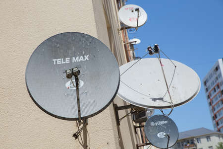 Azerbaijan Baku 20.05.2020 . Satellite dishes on the old house. Satellite TV on the wall of a multistory building . Satellite dish antennas . A bird sit at the satellite dish with other dishesのeditorial素材