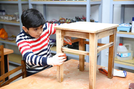 Azerbaijan Baku 17.05.2020 . Children clean to paint the top of the chair . The children paint the top of the chair.のeditorial素材