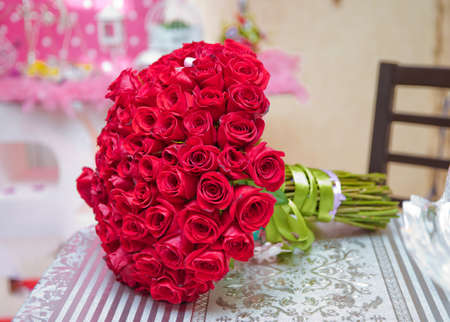 A bouquet of flowers bouquet of a hundred red roses . Big bouquet of one hundred big red roses flowers on the table .の写真素材
