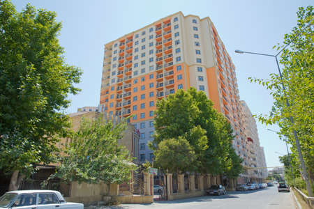 Azerbaijan Baku 04.08, 2017. Facade of modern multi-storey new residential orange building near Baku . New apartment house . Storey houses modern . High rise residential buildings under the blue skyのeditorial素材